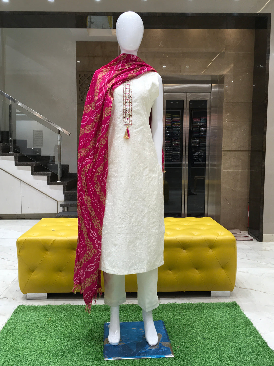 Cream Chanderi Cotton Straight Cut Salwar Kameez with mirror patch neckline, thread embroidery, vine sequin detailing, and dual-tone bandhani dupatta.