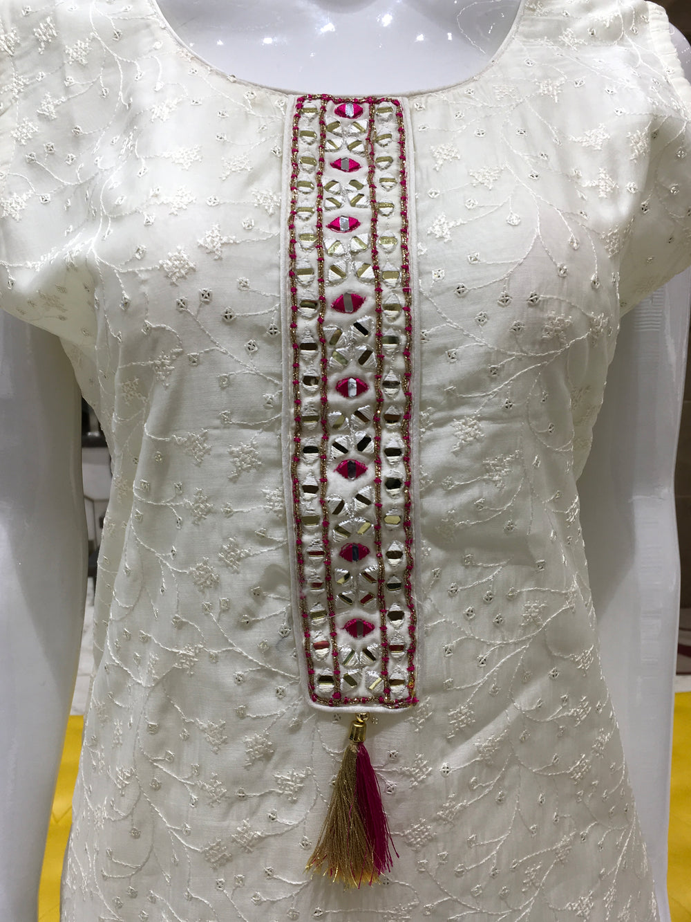 Cream Chanderi Cotton Straight Cut Salwar Kameez with mirror patch neckline, thread embroidery, vine sequin detailing, and dual-tone bandhani dupatta.
