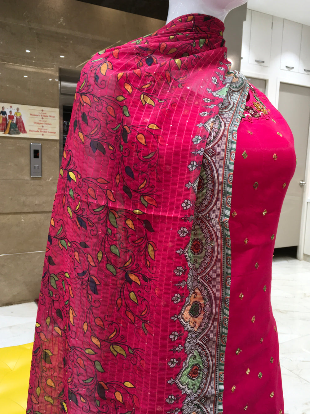 Chanderi Cotton Straight Cut Salwar Kameez with embroidered neckline, mirror detailing, pencil pant, and floral printed chiffon dupatta.