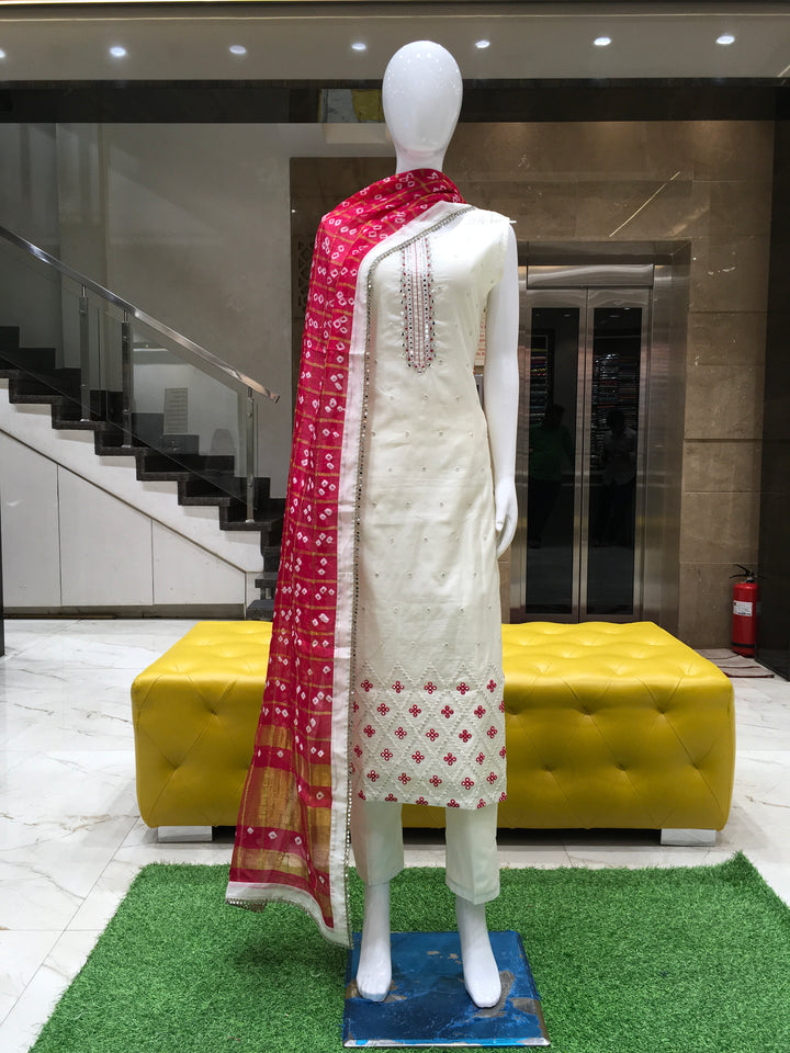 Cream Chanderi Cotton Straight Cut Salwar Kameez with thread embroidery, mirror detailing, pencil pant, and bandhani printed chiffon dupatta.