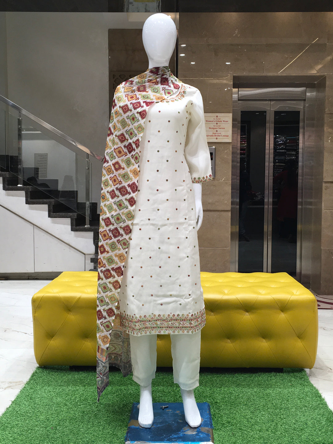 White Chanderi Cotton Straight Cut Salwar Kameez with floral embroidery, sequins, and a multicolor printed dupatta displayed on a mannequin.

